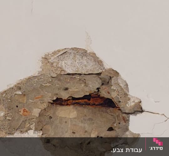 קיר עם טיח מתקלף וחור חשוף